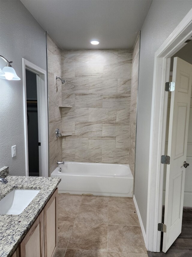 bathroom with vanity, tiled shower / bath combo, and tile patterned flooring