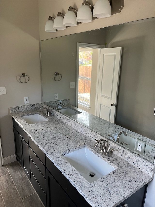 bathroom with dual vanity and hardwood / wood-style flooring