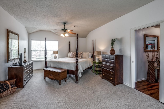 bedroom featuring lofted ceiling, baseboards, dark colored carpet, and a textured ceiling