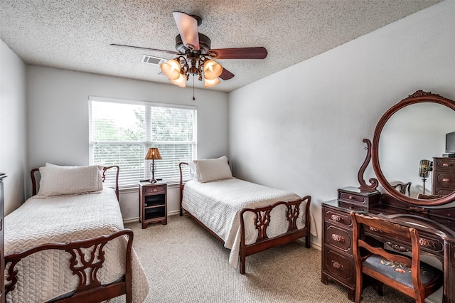 bedroom with light carpet, baseboards, visible vents, ceiling fan, and a textured ceiling