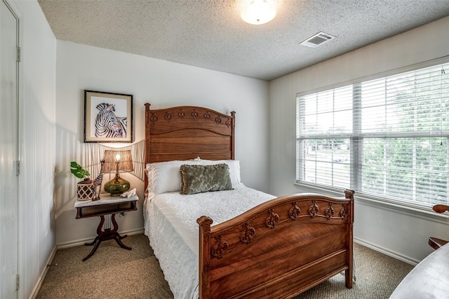 bedroom with baseboards, carpet, visible vents, and a textured ceiling