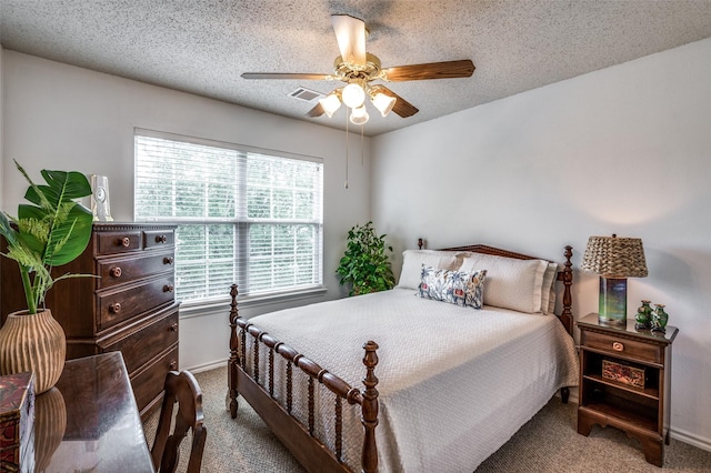 bedroom with a textured ceiling, ceiling fan, carpet flooring, and visible vents