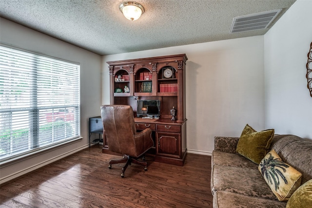 office area featuring baseboards, visible vents, dark wood finished floors, and a textured ceiling