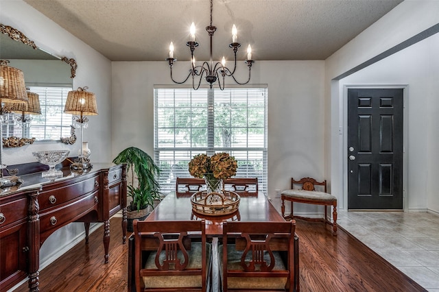 dining space featuring a chandelier, plenty of natural light, a textured ceiling, and wood finished floors