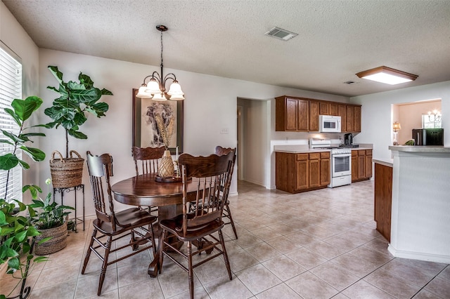 dining room featuring light tile patterned floors, visible vents, and an inviting chandelier