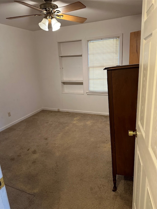 carpeted spare room with ceiling fan