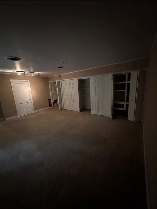 unfurnished bedroom with multiple closets and carpet