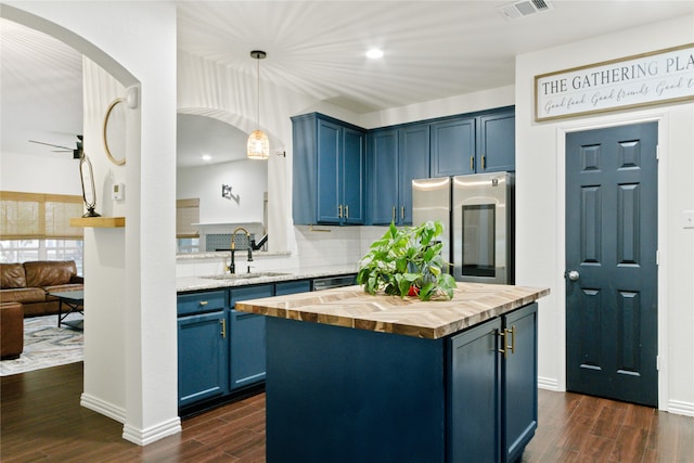 kitchen featuring a center island, sink, stainless steel fridge, and blue cabinetry