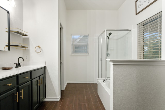 bathroom with a healthy amount of sunlight, hardwood / wood-style floors, vanity, and independent shower and bath