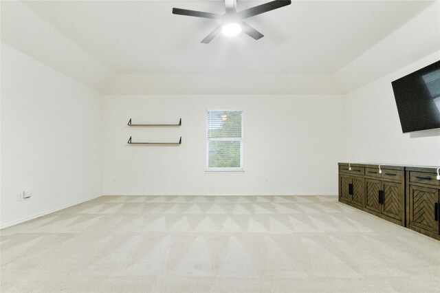 unfurnished living room with light carpet, ceiling fan, and a raised ceiling