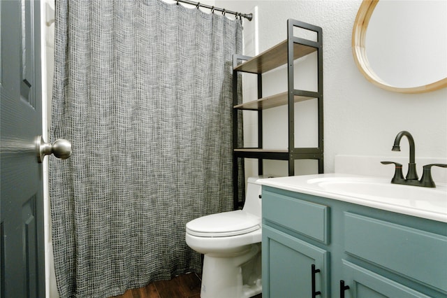 bathroom featuring oversized vanity, toilet, and hardwood / wood-style floors