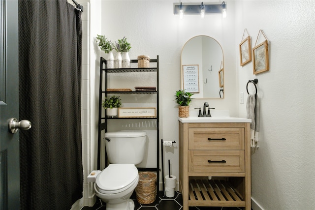 bathroom with tile flooring, toilet, and vanity