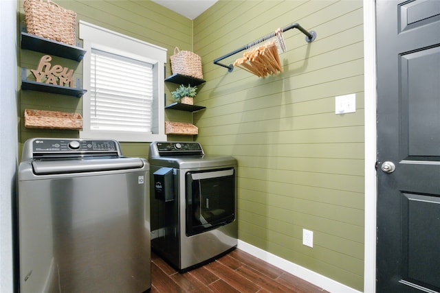 laundry area with wood walls, separate washer and dryer, and dark hardwood / wood-style flooring