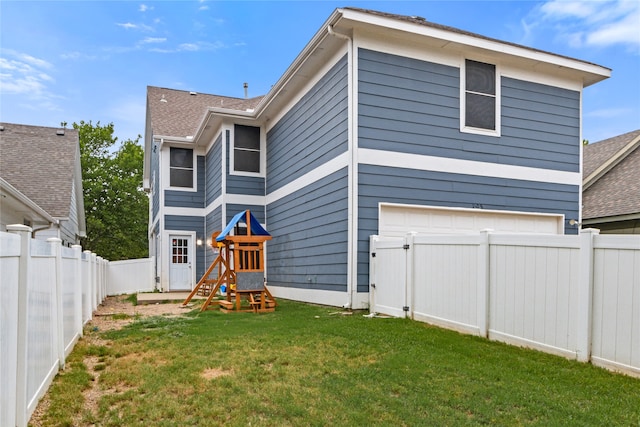 rear view of property with a yard and a garage