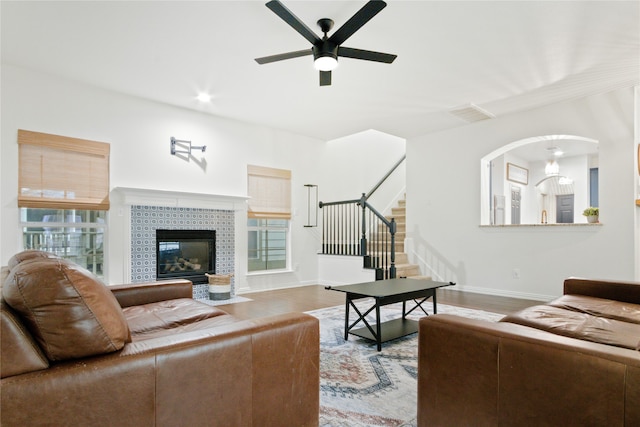 living room with ceiling fan, a fireplace, and hardwood / wood-style flooring