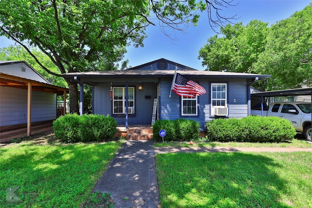 view of front facade featuring a carport, covered porch, and a front yard