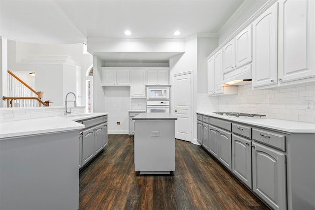 kitchen with white appliances, sink, dark hardwood / wood-style floors, and a kitchen island