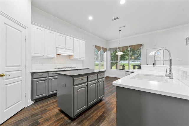 kitchen featuring dark hardwood / wood-style floors, gray cabinets, decorative light fixtures, and sink