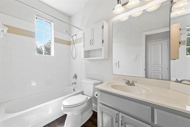 full bathroom with hardwood / wood-style floors, oversized vanity, toilet, and tiled shower / bath