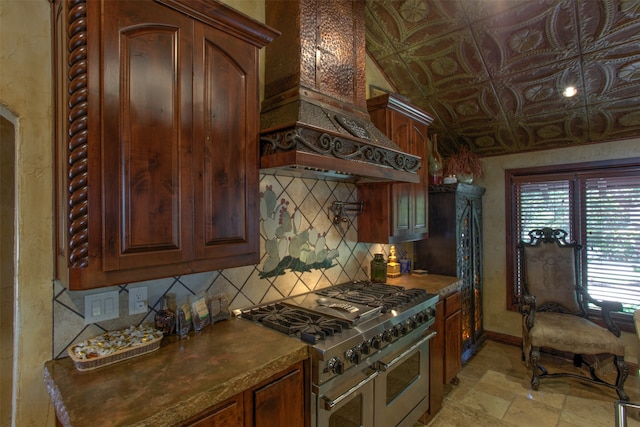 kitchen with vaulted ceiling, double oven range, premium range hood, backsplash, and light tile floors