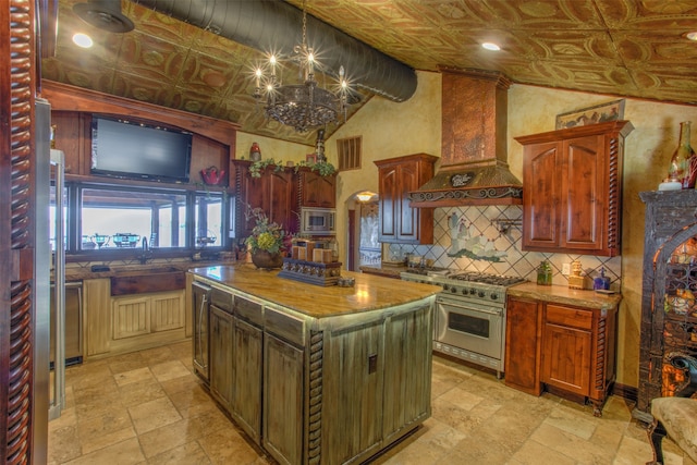 kitchen featuring a center island, appliances with stainless steel finishes, a chandelier, light tile floors, and custom exhaust hood