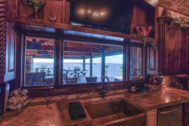 kitchen featuring a water view, plenty of natural light, sink, and tasteful backsplash