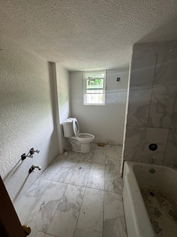 bathroom featuring tile flooring and a textured ceiling