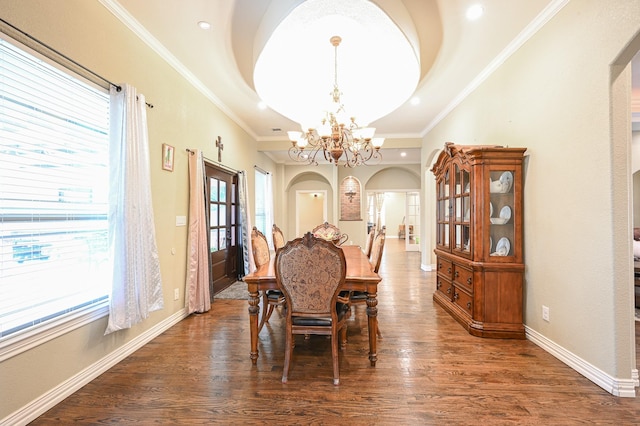 dining area with a raised ceiling, dark hardwood / wood-style flooring, crown molding, and a chandelier