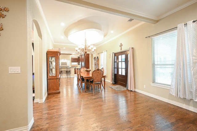 dining room with hardwood / wood-style floors, a tray ceiling, crown molding, and a notable chandelier