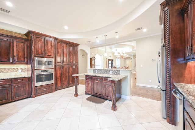 kitchen featuring light stone counters, ornamental molding, stainless steel appliances, decorative light fixtures, and a chandelier