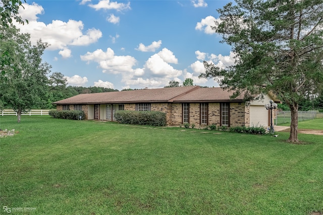 ranch-style home with a garage and a front lawn