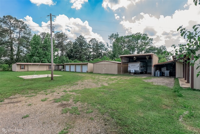 view of yard featuring an outdoor structure and a garage