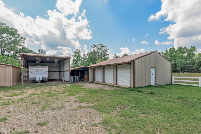 view of shed / structure with a garage, a carport, and a yard