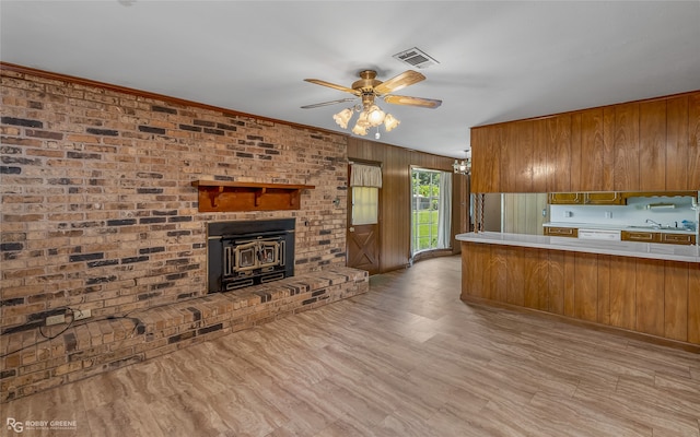 kitchen featuring brick wall, a fireplace, ceiling fan, hardwood / wood-style flooring, and sink