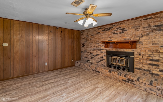 unfurnished living room with brick wall, ceiling fan, and light hardwood / wood-style flooring