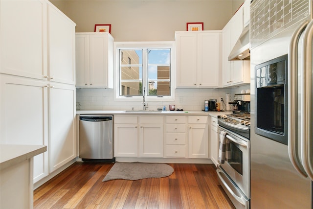 kitchen featuring sink, appliances with stainless steel finishes, dark hardwood / wood-style floors, and white cabinets