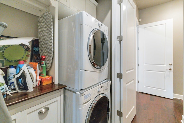 laundry room featuring stacked washing maching and dryer and dark hardwood / wood-style floors