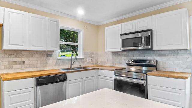 kitchen featuring white cabinets, butcher block countertops, appliances with stainless steel finishes, and sink