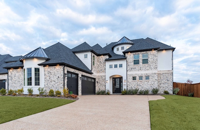 french provincial home with a garage and a front lawn