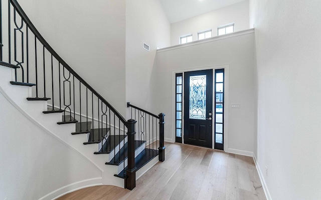 foyer with a high ceiling and light hardwood / wood-style flooring