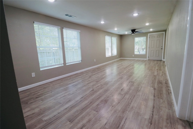 spare room with ceiling fan, a healthy amount of sunlight, and light wood-type flooring