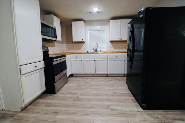 kitchen with backsplash, sink, white cabinets, and black appliances