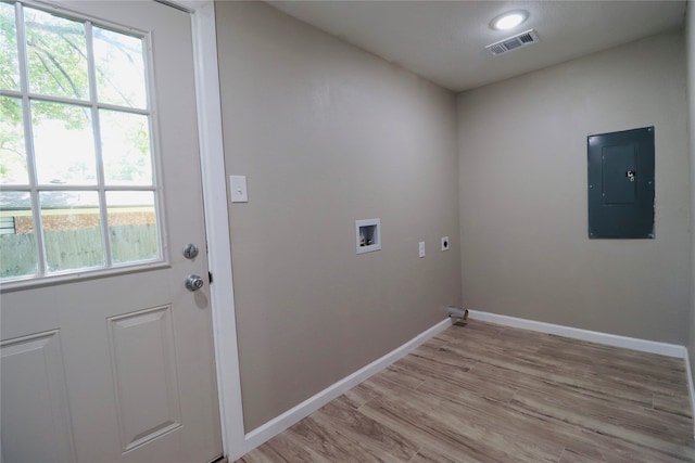 washroom with hookup for an electric dryer, electric panel, light hardwood / wood-style floors, and hookup for a washing machine