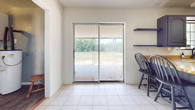 kitchen featuring light tile patterned flooring and water heater