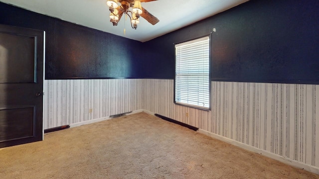 spare room with ceiling fan and carpet