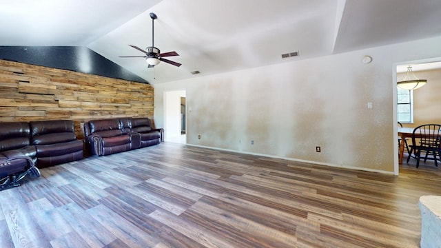 unfurnished living room with ceiling fan, hardwood / wood-style floors, and vaulted ceiling