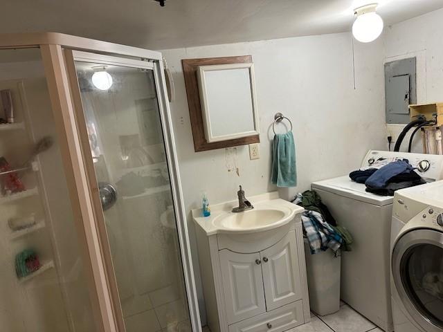 washroom with washer and dryer, electric panel, a sink, light tile patterned flooring, and laundry area