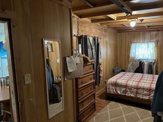 bedroom with beamed ceiling and wood walls