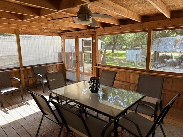 sunroom featuring beamed ceiling, a wealth of natural light, and ceiling fan