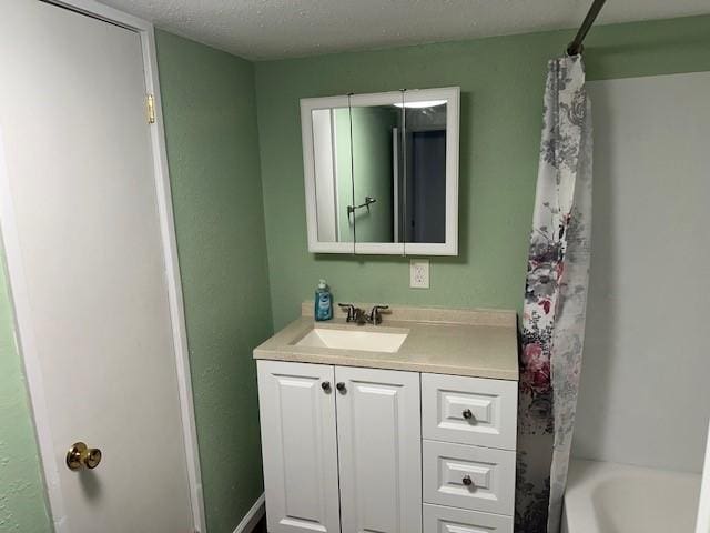 full bath featuring vanity, shower / bathtub combination with curtain, and a textured ceiling